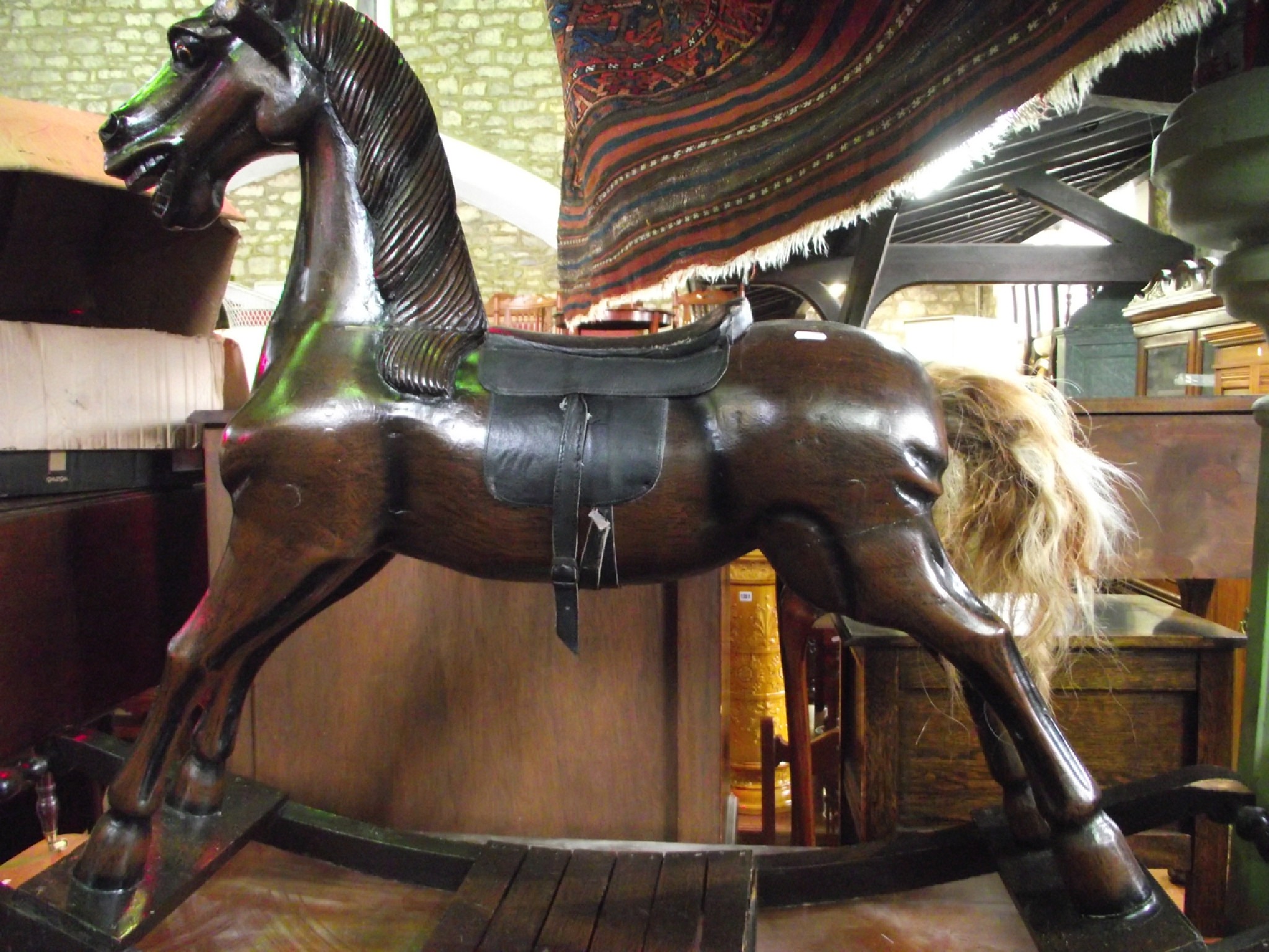 Appraisal: A contemporary stained hardwood rocking horse with carved mane and