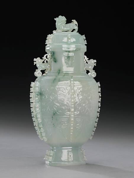 Appraisal: A carved jadeite zun-form covered vase th Century Its angular