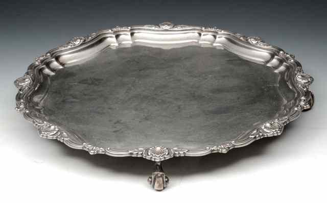 Appraisal: A SMALL SILVER SALVER with scroll supports and pie-crust border