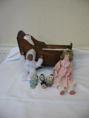 Appraisal: A small pine doll's cradle wide containing two small porcelain