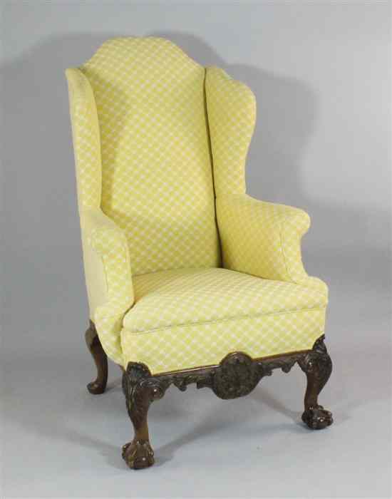 Appraisal: A George I design carved mahogany wingback armchair with pale