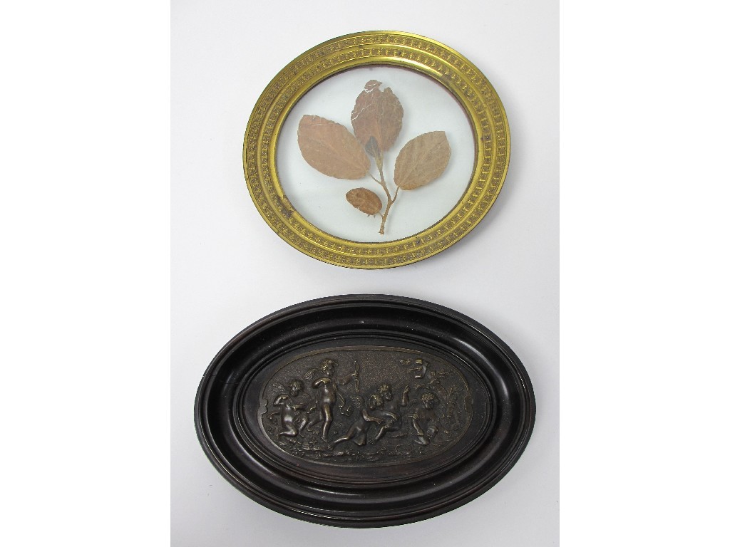 Appraisal: A French bronze plaquette cast with cupid within an ebonised