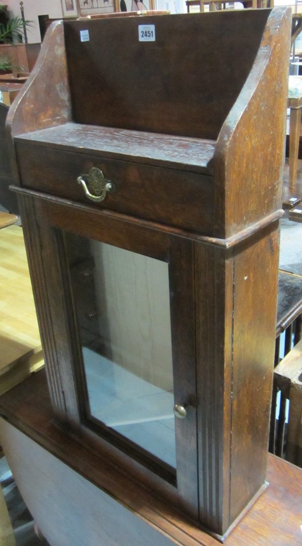 Appraisal: An oak wall cupboard with glazed door and drawer