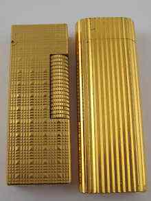 Appraisal: A gold plated Cartier cigarette lighter and a similar Dunhill