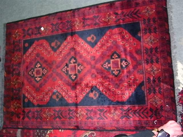 Appraisal: A SIMILAR TURKISH RED GROUND RUG with shaped central medallion