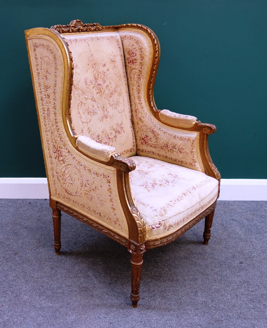 Appraisal: A Louis XVI style carved giltwood wingback armchair with semi