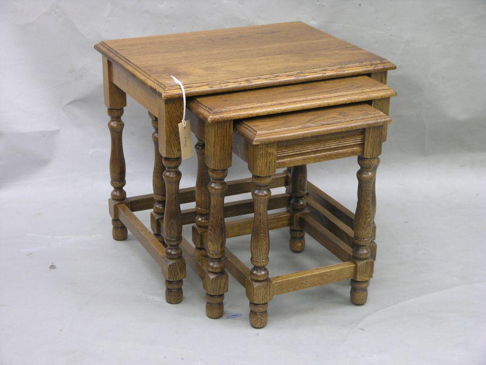 Appraisal: A solid medium oak nest of three tables on baluster