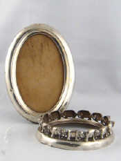 Appraisal: A silver oval strut back photo frame Birmingham together with