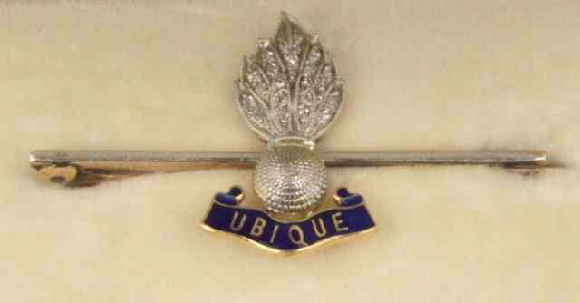 Appraisal: A diamond and enamel Royal Artillery bar-brooch with flaming grenade