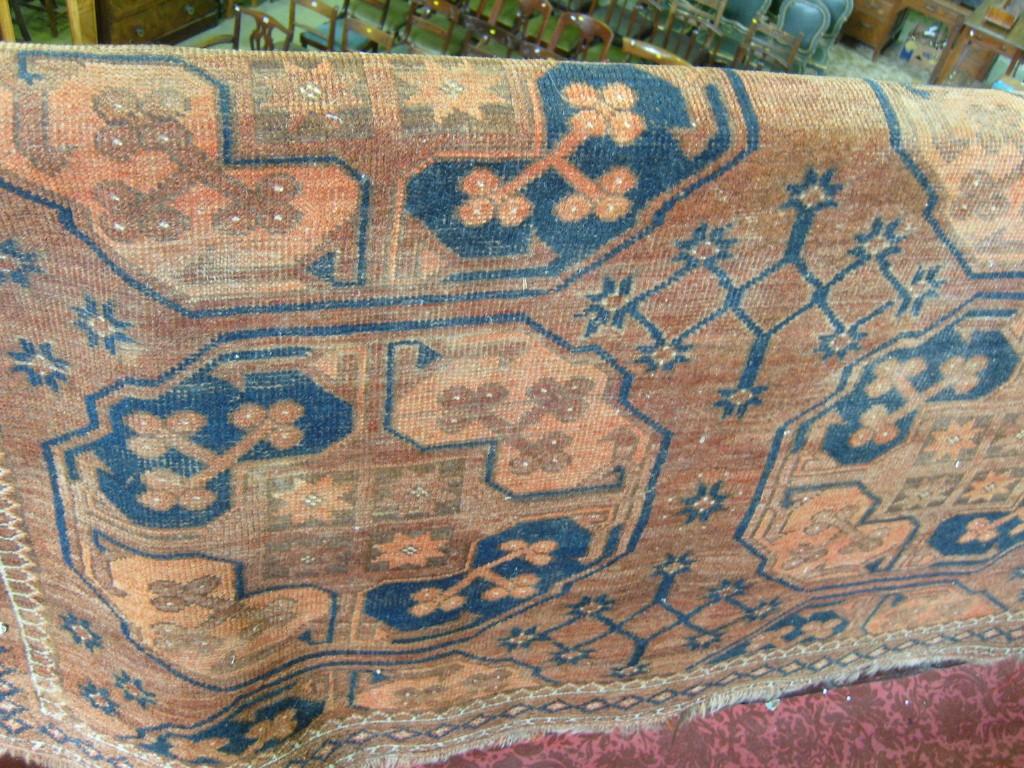 Appraisal: An eastern wool rug with stylised floral and repeating border