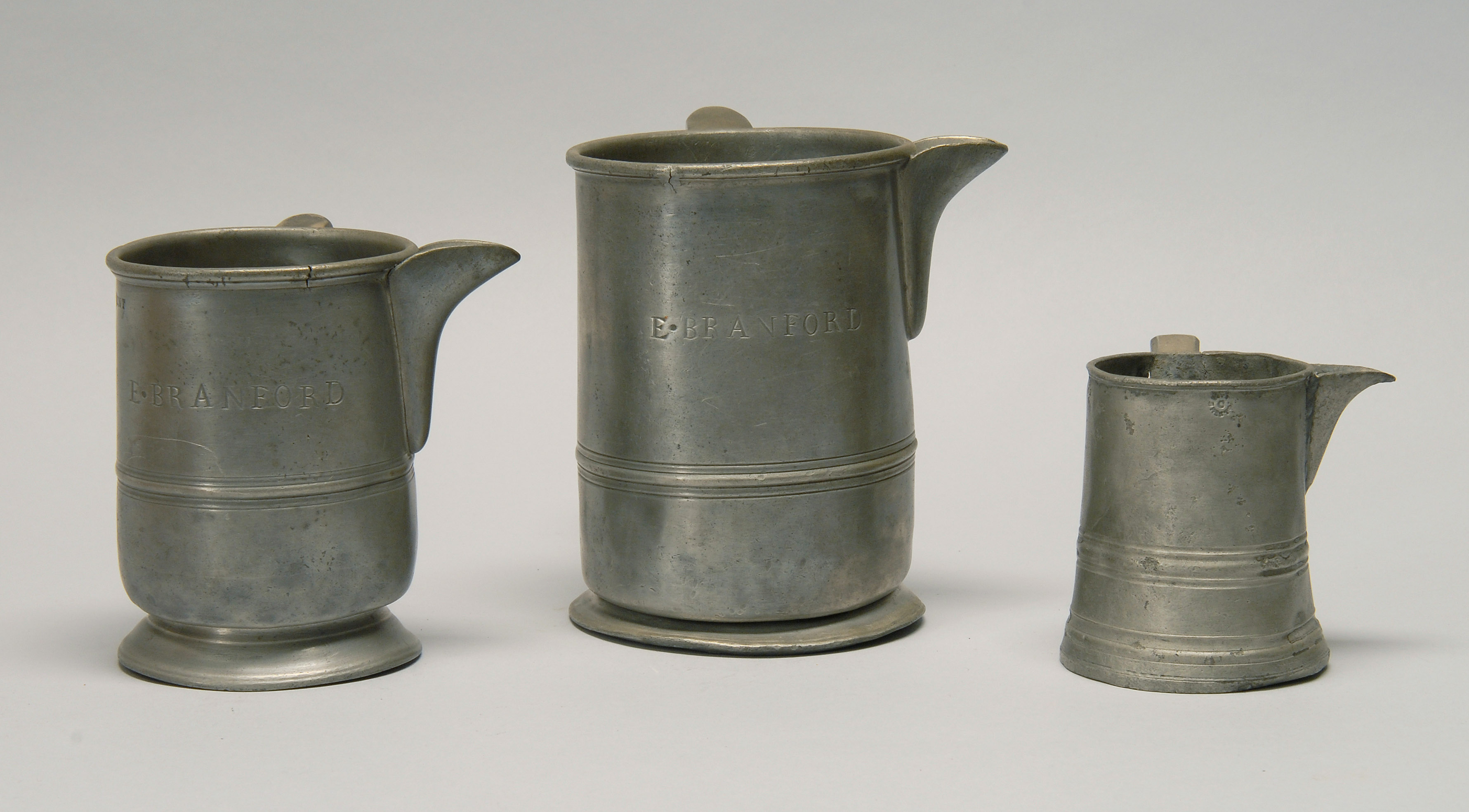 Appraisal: THREE ENGLISH PEWTER MEASURES Early th CenturyAll with pouring lips