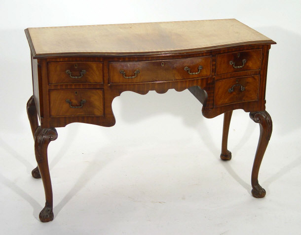 Appraisal: Walnut kneehole dressing table the sepentine front above an arrangement