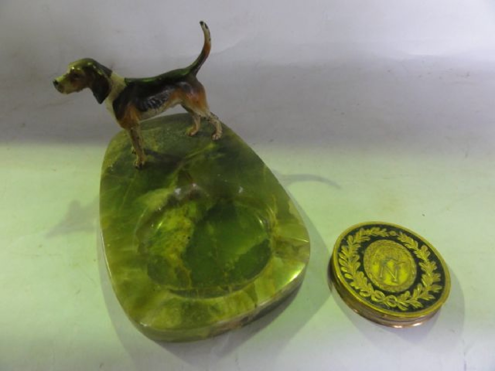 Appraisal: A polished onyx ashtray set with a painted metalwork figure