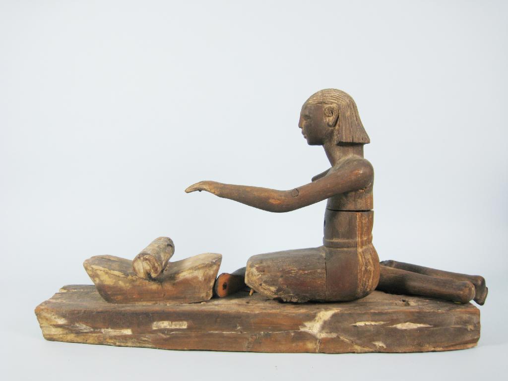 Appraisal: An Egyptian style carved wood Figure of a kneeling woman