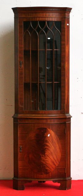 Appraisal: A mahogany and flamed mahogany reproduction corner cabinet with serpentine