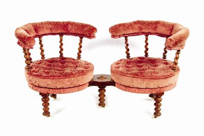 Appraisal: A Victorian walnut conversation settee with two revolving seats on