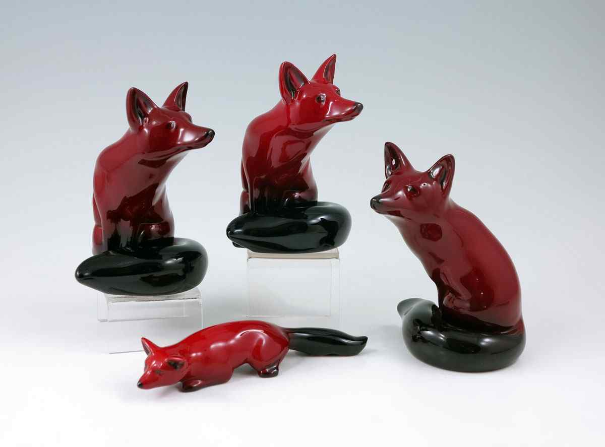 Appraisal: ROYAL DOULTON FLAMBE FOX FIGURINES Three sitting foxes '' tall