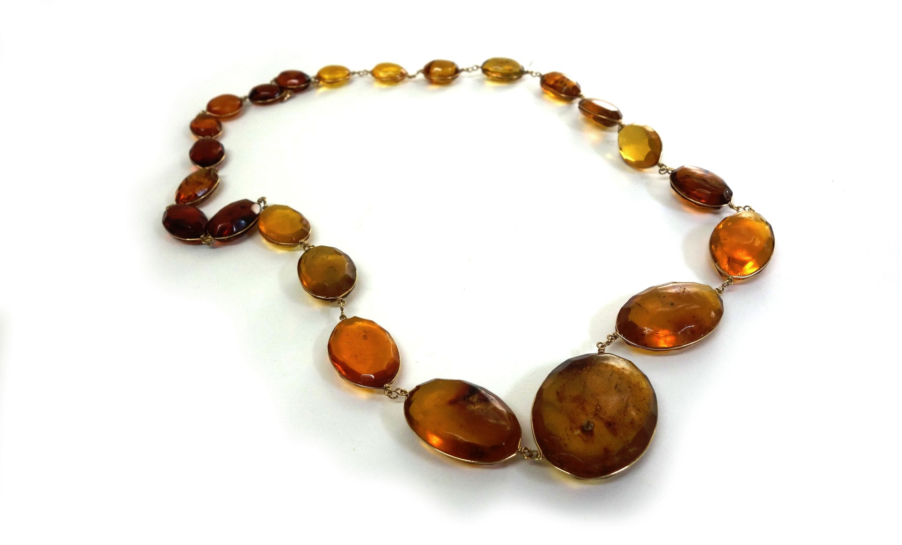 Appraisal: A gold spectacle set amber necklace the twenty-three oval translucent