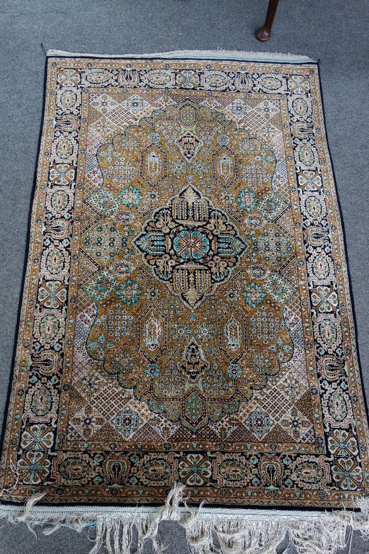 Appraisal: A Qum silk rug with central black medallion and mustard