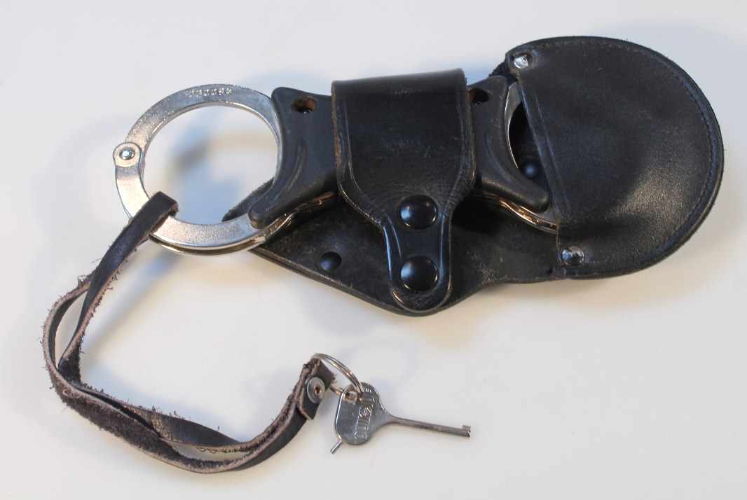 Appraisal: A pair of late thC Civil Defence supply quick handcuffs