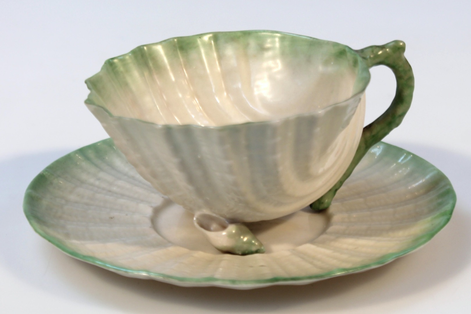 Appraisal: An early thC Belleek shell shaped cup and saucer in