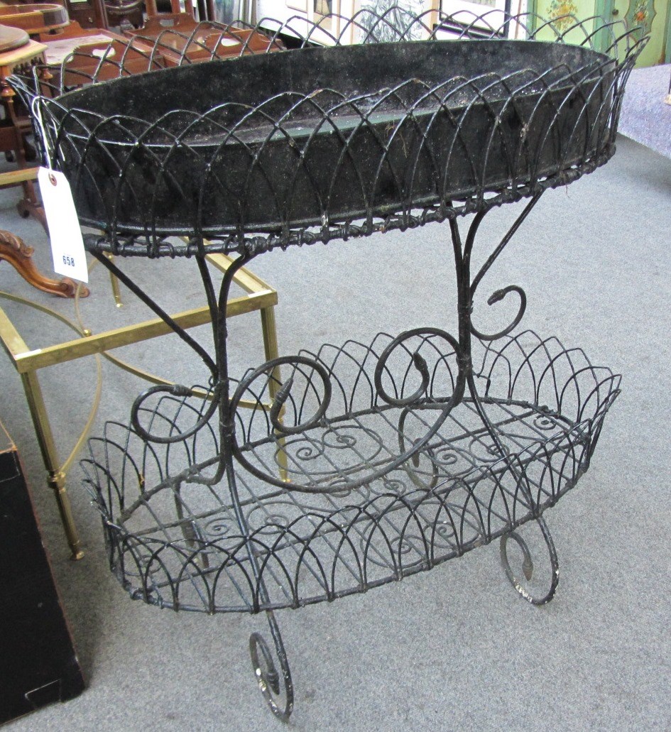 Appraisal: A black painted Edwardian wrought iron oval two tier jardiniere