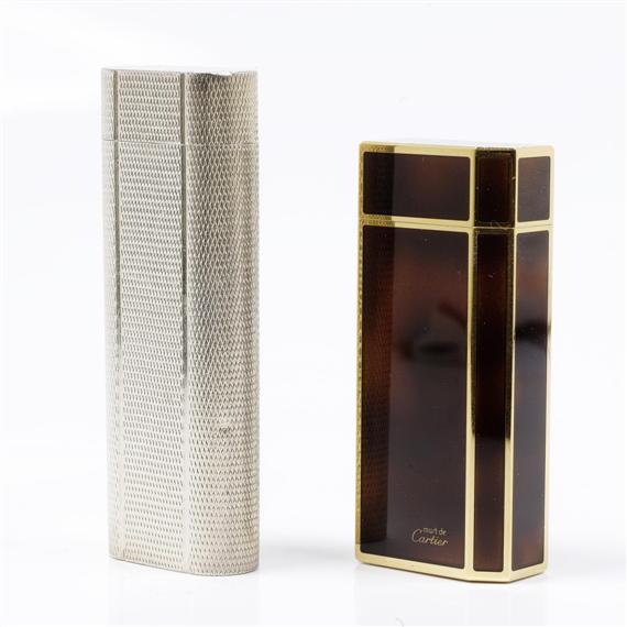 Appraisal: LOT TWO LIGHTERS CARTIER Rectangular gold-coloured lighter the walls decorated