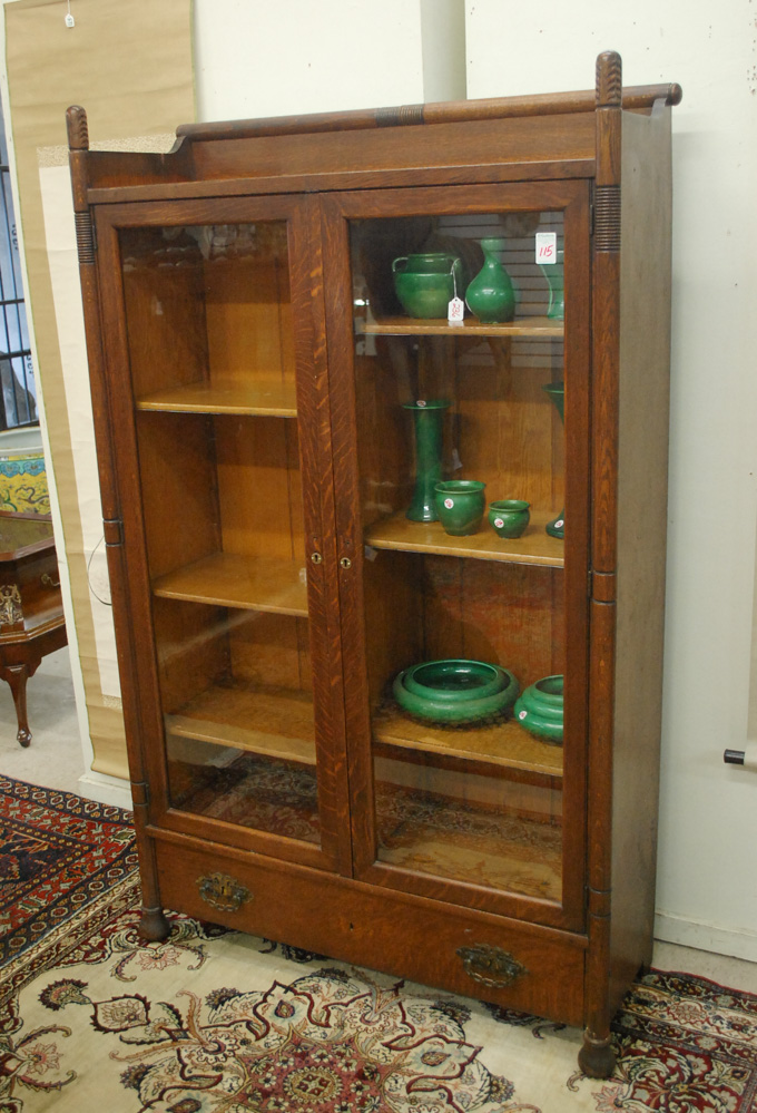 Appraisal: TWO-DOOR OAK CABINET BOOKCASE American c having two long glass-panel