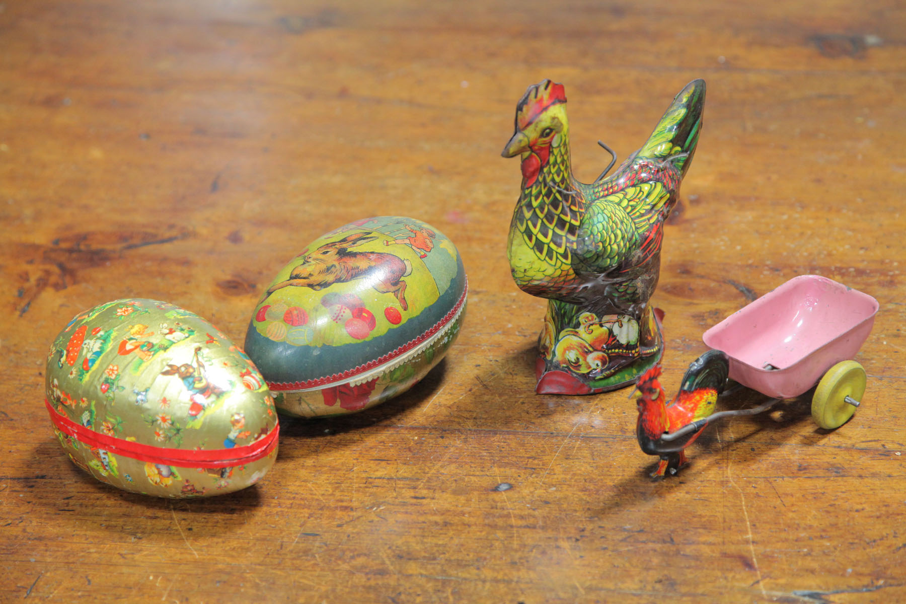 Appraisal: TWO PAPER MACHE EGGS AND TWO TIN TOYS American and