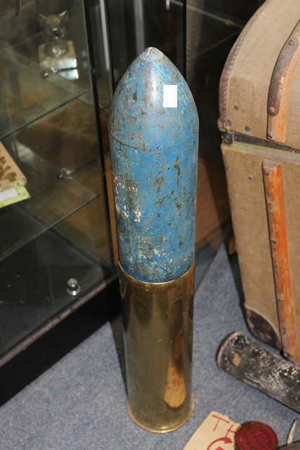 Appraisal: A LARGE BRASS ARTILLERY SHELL with blue painted nose cone