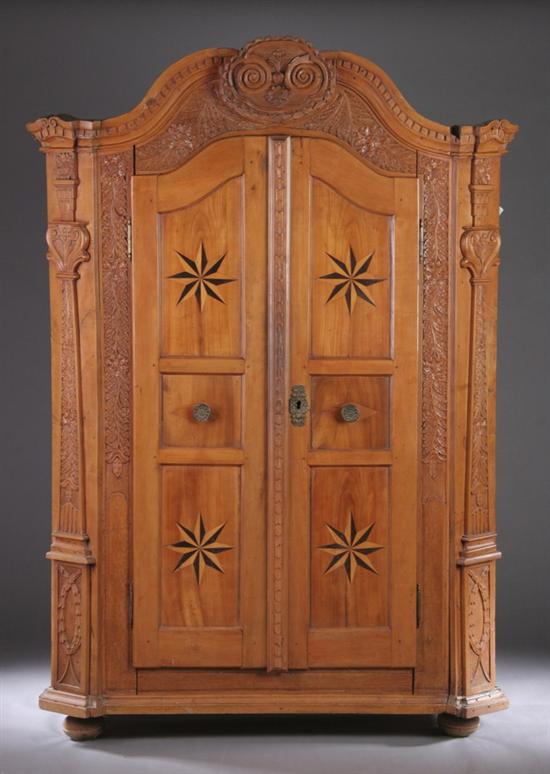 Appraisal: FRENCH PROVINCIAL CARVED AND INLAID ARMOIRE th century Scrolling broken-arch