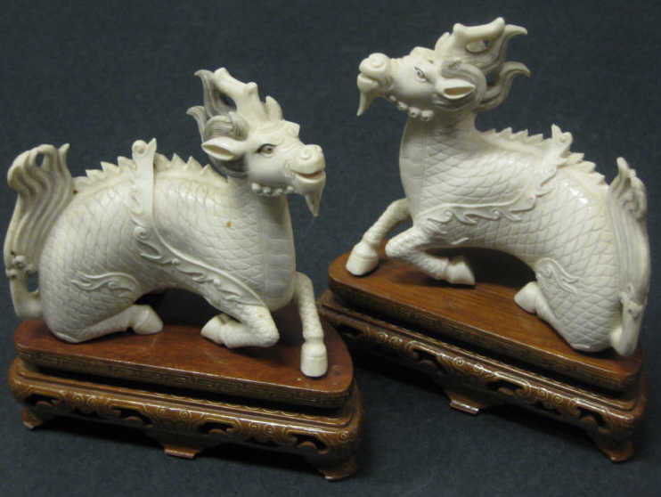 Appraisal: PAIR OF CHINESE IVORY ANIMAL HYBRIDS Each carved as one-horn