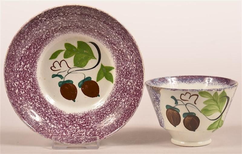 Appraisal: Purple Spatter Acorn Pattern Cup and Saucer Purple Spatter Acorn