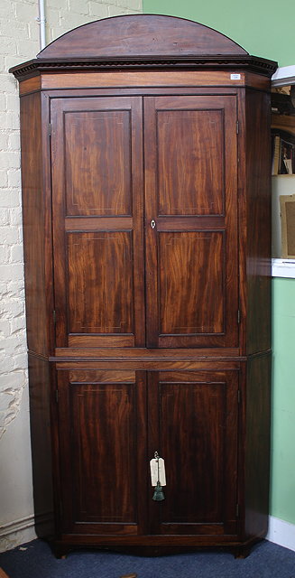 Appraisal: A REGENCY MAHOGANY FLOOR STANDING CORNER CUPBOARD in two sections