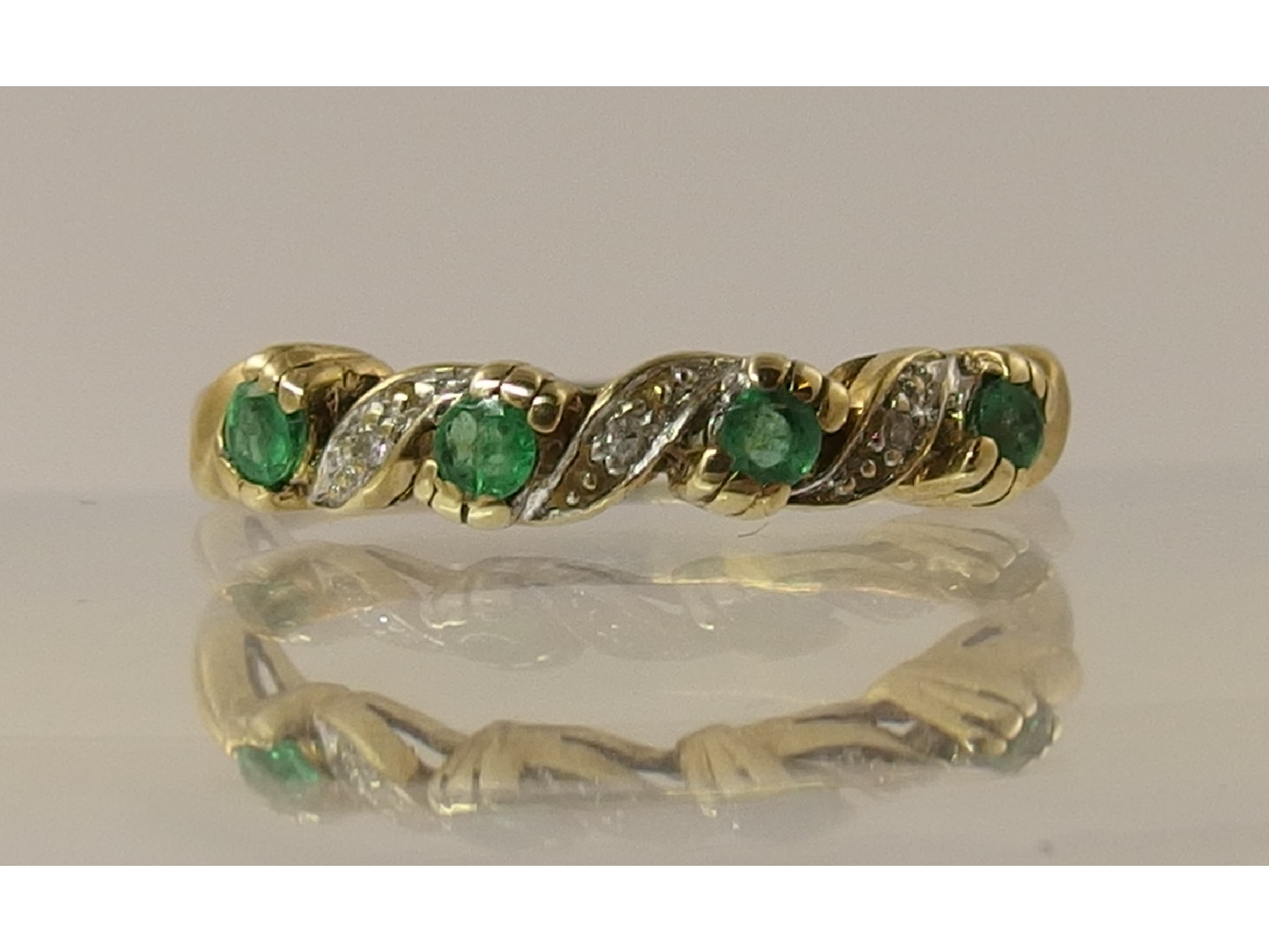 Appraisal: A ct emerald and diamond half eternity ring