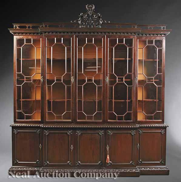 Appraisal: A Chippendale-Style Carved Mahogany Breakfront reticulated Chinese Chippendale crest geometrically