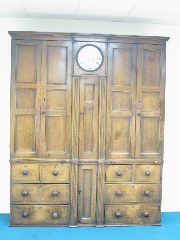 Appraisal: An early th Century oak Shropshire Housekeeper's Cupbaord fitted clock