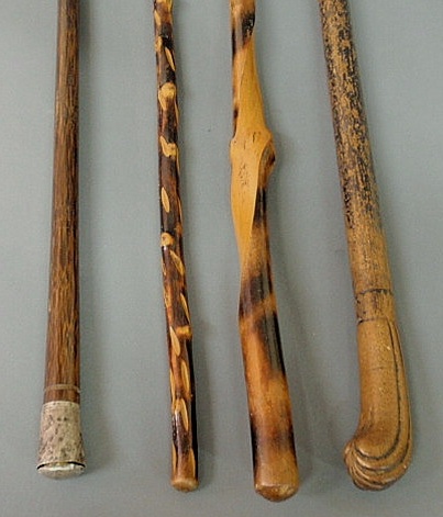 Appraisal: Four walking sticks canes including a carved handle example Approx