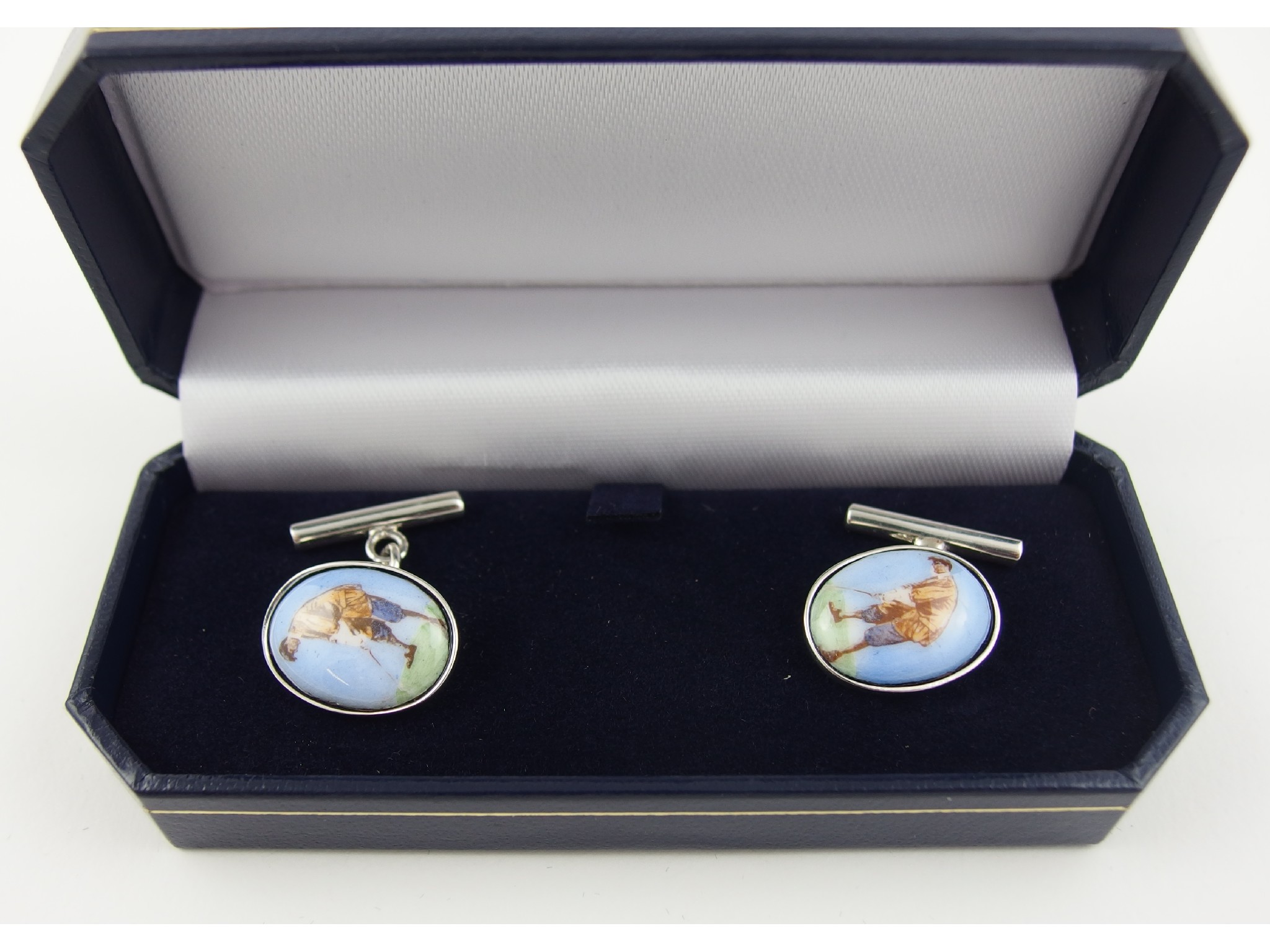 Appraisal: A pair of silver cufflinks depicting golfers