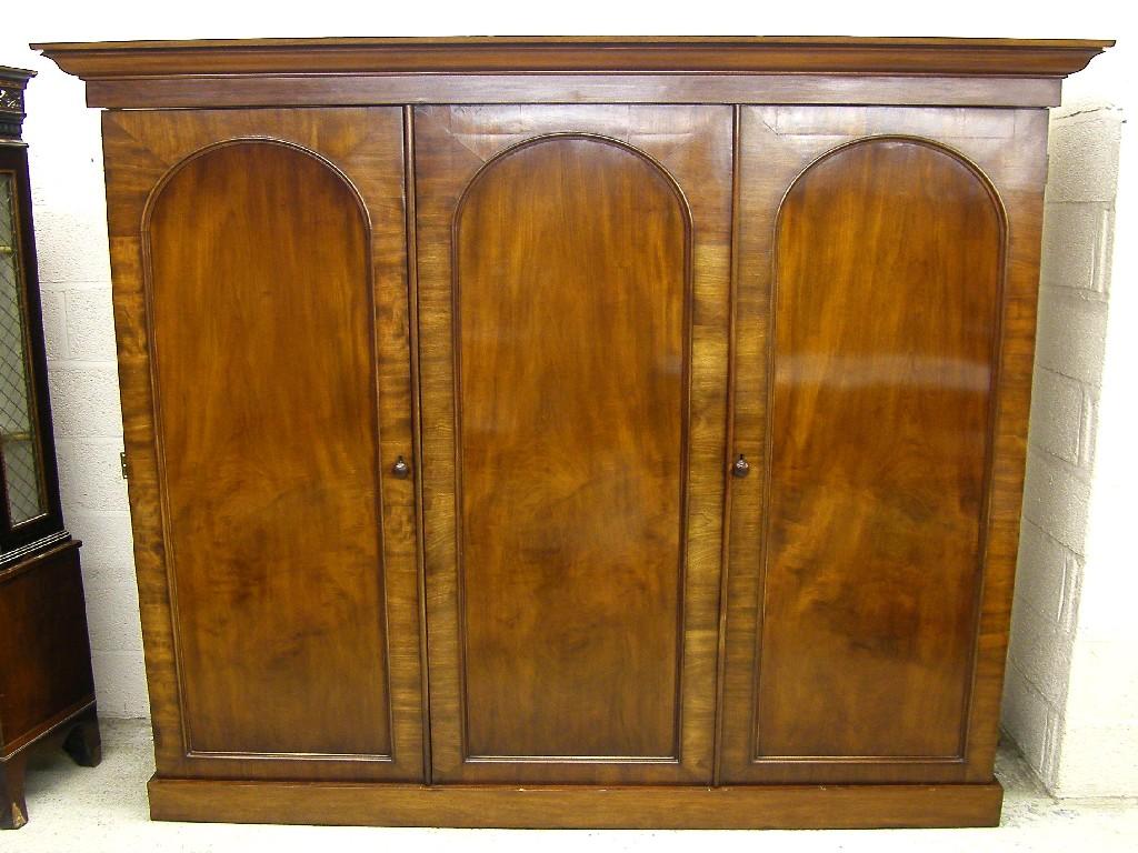 Appraisal: Victorian mahogany triple wardrobe the moulded cornice over three arched