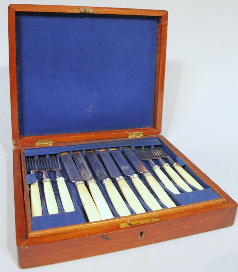 Appraisal: An Edwardian mahogany cased canteen of cutlery comprising knives and