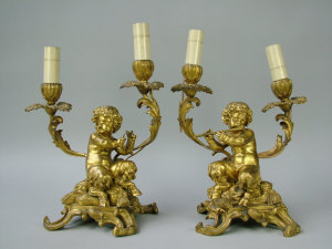 Appraisal: A pair of twin branch gilt bronze child satyr candelabra