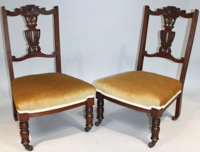 Appraisal: A pair of Edwardian stained walnut nursing chairs each with