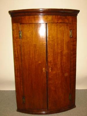 Appraisal: A GEORGE III MAHOGANY CORNER CUPBOARD of bowed form with