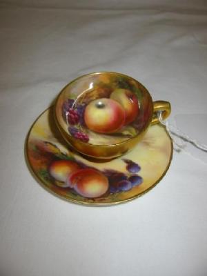 Appraisal: A ROYAL WORCESTER PORCELAIN MINIATURE TEA CUP AND SAUCER painted