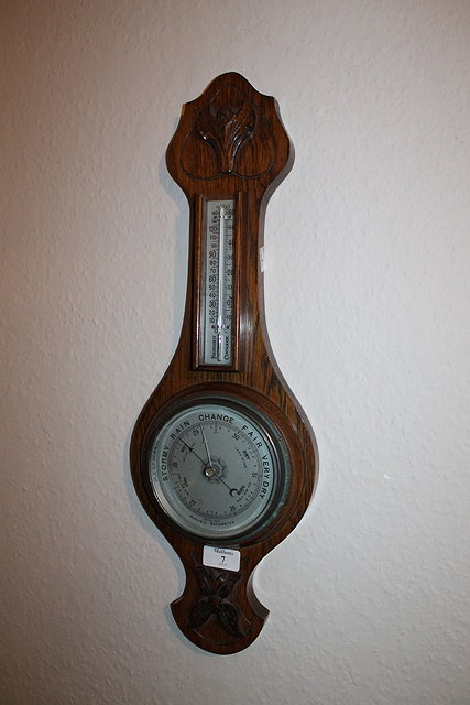 Appraisal: AN OAK ANEROID BAROMETER with carved decoration cm