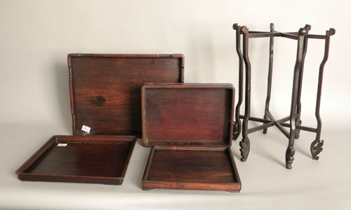 Appraisal: Four Chinese teak trays together with a folding stand