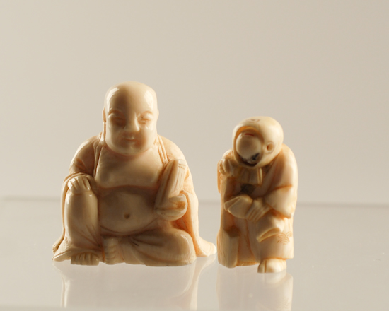 Appraisal: Two Japanese Carved Ivory Figures a netsuke of a hooded