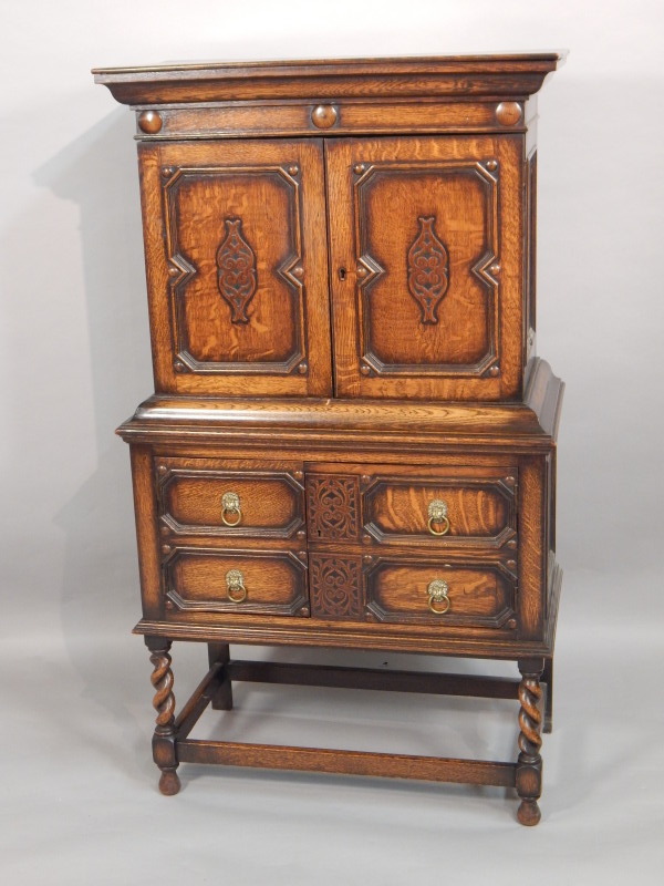 Appraisal: A reproduction oak side cabinet in the style of a