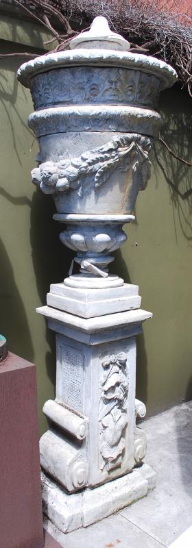 Appraisal: A PAIR OF COMPOSITE STONE URNS ON PLINTHSeach with swan